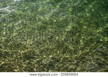 Up view crystal transparent fresh river sea water with stones, free space