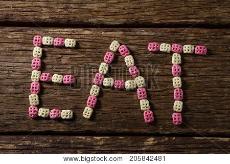 Honeycomb cereal arranged eat text on wooden table