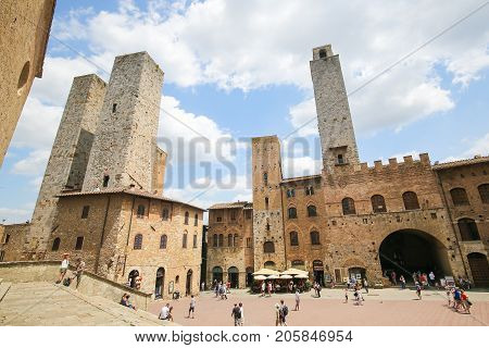 SAN GIMIGNANO ITALY - JULY 11 2017: Medieval Towers including the famous Torre Chigi in San Gimignano the Town of Fine Towers in Tuscany Italy