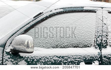 Closeup of a car covered in snow