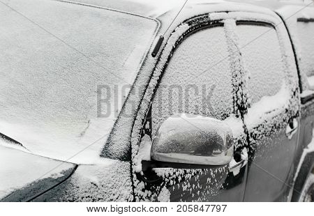 Closeup of a car covered in snow
