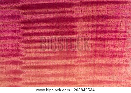 Finished wood surface with beautiful figured grain.Wood has tiger stripe or curly stripe grain. colored with translucent magenta / purple dye and lacquer top coat.