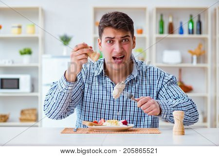 Man eating tasteless food at home for lunch