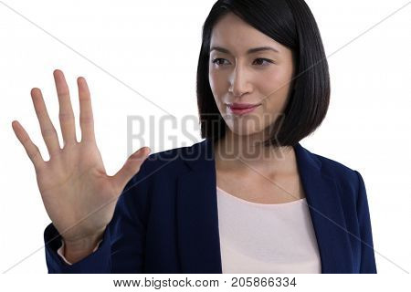 Businesswoman touching invisible screen against white background