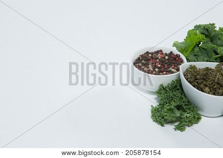 Close up of pepercorn and kale on white background