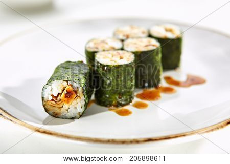 Maki rolls with tamagoyaki served on white flat plate. Asian menu for gourmets in luxury restaurant