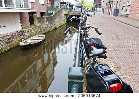 Urban scene in Amersfoort with typical local architecture and many bicycles. Street View with bikes parked on an embankment in the historical center of Amersfoort in the Netherlands