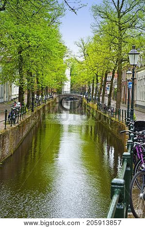 Urban scene in Amersfoort with typical local architecture and many bicycles. Street View with bikes parked on an embankment in the historical center of Amersfoort in the Netherlands