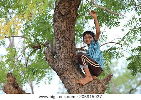 cute indian poor child playing cricket  at village