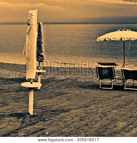 Beach Umbrella and Sun Bed in the Sandy Coast near the Italian City of Minori at Sunset