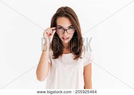 Pretty brunette woman in eyeglasses looking at the camera over white background