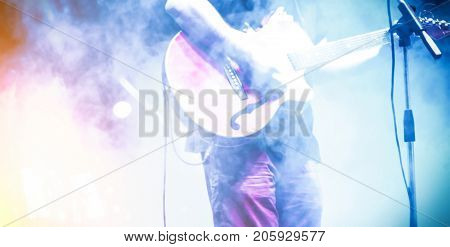 Frontman with guitar in the smoke on the stage