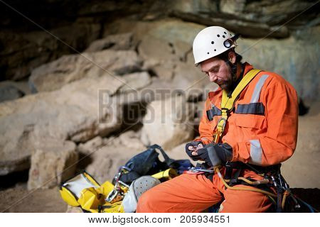 Speleologist performing rope maneuvers in a cave. Zaragoza Province, Aragon, Spain.