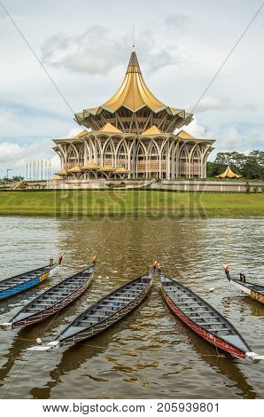 The new Parliament, Kuching, Sarawak, under the water festival in November 2016. Longboats lay on river in front of the building. Dramatic clouds behind.