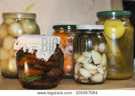 Assortie Jars Of Marinated Vegetables Picles Tomato On Wooden Background