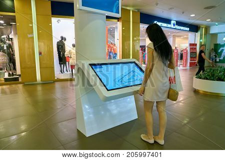 SAINT PETERSBURG, RUSSIA - CIRCA AUGUST, 2017: woman use information kiosk at Galeria shopping center. Galeria is major shopping and entertainment center is located in downtown of St. Petersburg