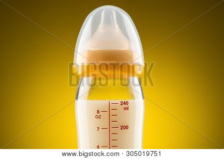 Backlit Glass Baby Bottle With Powdered Milk Closeup On The Upper Part