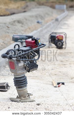 Close Up Of Vibrating Plate Compactor Machine At Road Construction Site