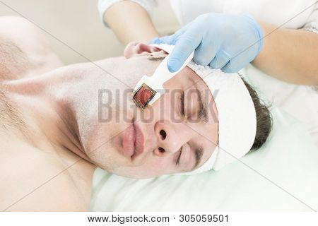Young Man On The Procedure Of Rejuvenation And Cleansing Of The Skin Of The Modern Medical Instrumen