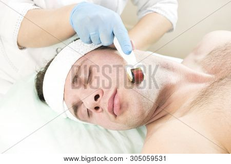 Young Man On The Procedure Of Rejuvenation And Cleansing Of The Skin Of The Modern Medical Instrumen