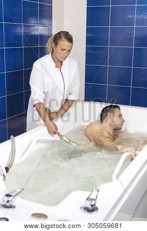 The Hydromassage Procedure In The Beauty Salon Is A Young Man Of Sports Appearance.