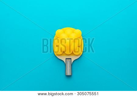 Table Tennis Racket And Pyramid Of Balls On It Over Turquoise Blue Background. Flat Lay Image Of Tab