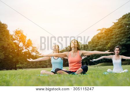 Yoga Woman On Green Grass.group Of Adults Attending A Yoga Class Outside In Park.family Or Friends E