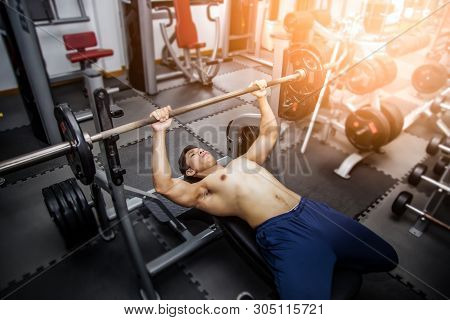 Muscular Man In Gym Doing Exercises With Dumbbells, Strong Male.