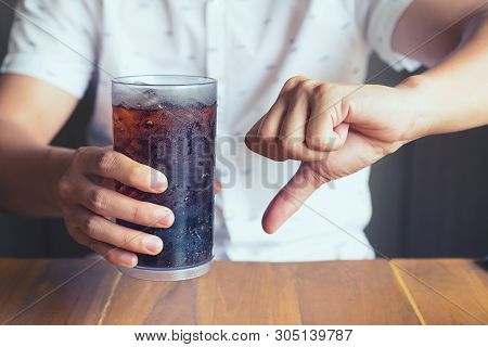Glass Of Softdrink Splashing With Ice On Hand Wooden Table Background, Not Good Bad For Health  Fing