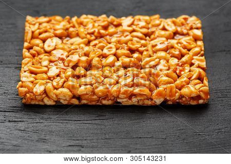 A Large Golden Tile Of Peanuts, A Bar In A Sweet Molasses On A Black Texture Background. Kozinaki Us