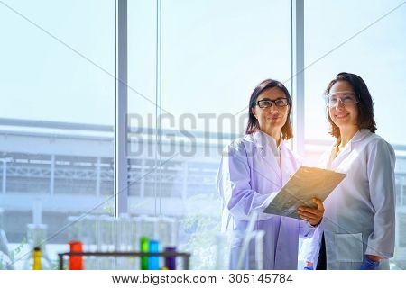 Young Female Scientist Standing With Techer In Lab Worker Making Medical Research In Modern Laborato