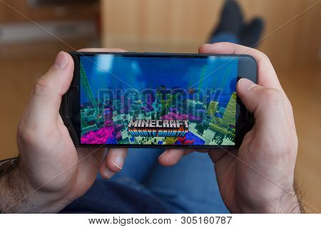 Los Angeles, California - June 3, 2019: Lying Man Holding A Smartphone And Playing Minecraft Game On