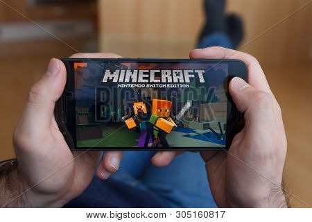 Los Angeles, California - June 3, 2019: Lying Man Holding A Smartphone And Playing Minecraft Game On