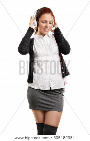 Portrait Of A Young Beautiful Woman Enjoying Music On Her Headphones, Isolated On A White Background