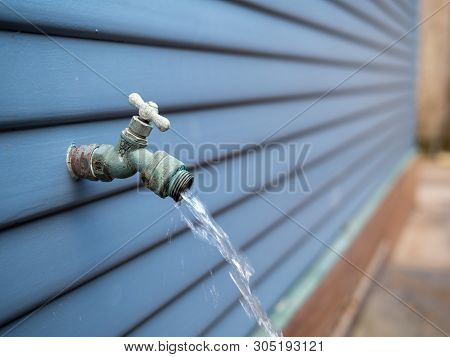 Water Streaming Out Of Outdoor Faucet For Garden Hose Outside Home