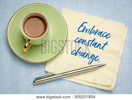 Embrace constant change - handwriting on a napkin with a cup of coffe