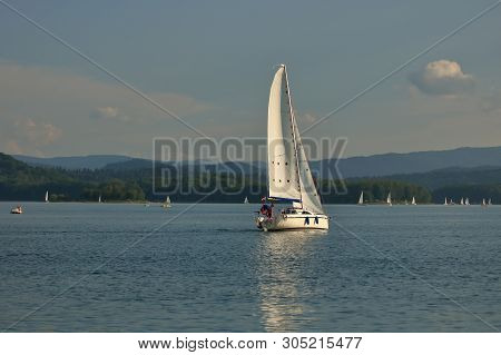 Summer Leaisure Activity, Yacht In The Middle Of Lake Solina, Poland, Surrounded By Hills