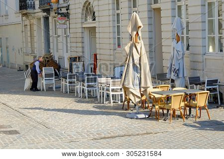 Place Des Martyrs, Brussels, Belgium, May 2019,  Man Setting Tables And Chairs Outside A Restaurant 