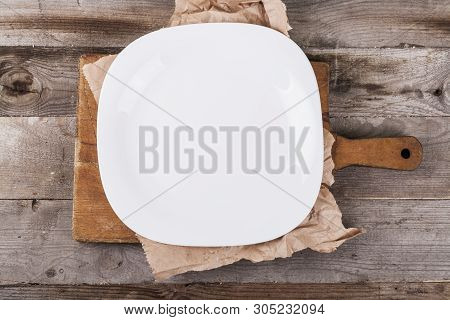 Light Empty Plate With Kitchen Accessories On A Wooden Background In Vintage Style.