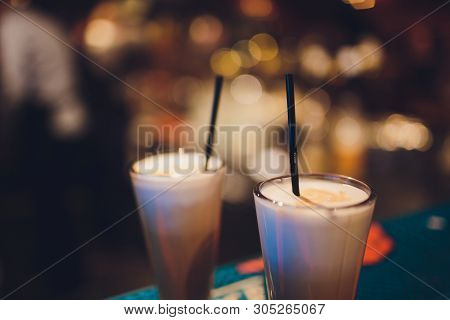 Two Delicious Thick Icecream Milkshakes Garnished With Chocolate And Mint And Served In Tall Chilled