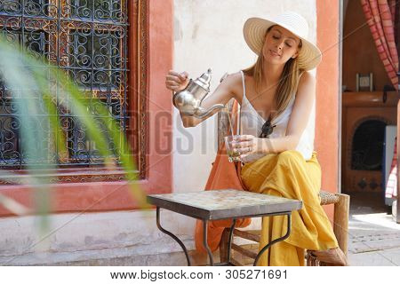 Elegant woman dirnking mint tea in Moroccan riad