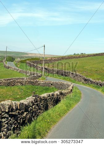 A Junction On A Winding Narrow Country Lane Bordered By Dry Stone Walls In Hilly Yorkshire Dales Cou