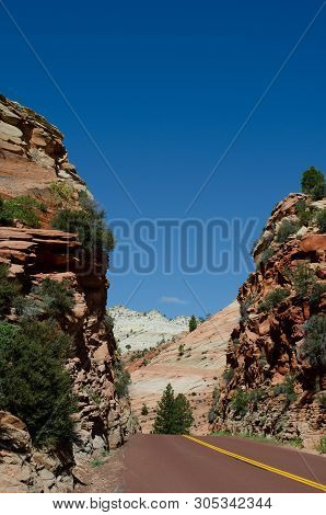 Zion Mount Carmel Highway East Of Zion National Park, Utah.  Road Disappearing Between Red And White