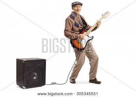 Full length portrait of a cheerful senior man playing an electric guitar plugged into an amplifier isolated on white background