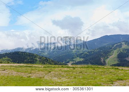 View Of Mountain With Rocky Foreground, Green Meadows, Tourist Path In Distance, Beautiful Nature, A