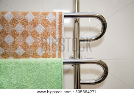 Modern Bathroom With Towel Warmer With Green And Brown Towel