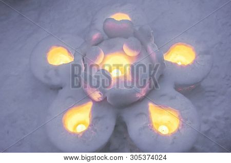 Closeup Snow Candles In A Big Flower Shape And Snow Floor Background. Snow Candles Are Activities Of