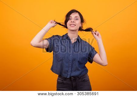 Happy Young Woman Happy About Her Shampoo For Her Demaged Hair In Studio Over Yellow Background