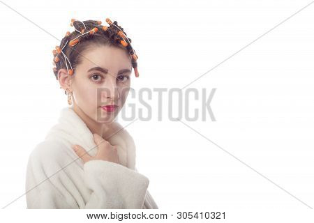 Young Woman With Hair Curlers On Head And Bathrobe Isolated On White Background With Copy Space Look