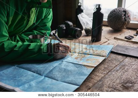 Young Man Planning His Trip In A Cabin With A Map On Lofoten Islands Near Stokkvika And Fredvang.